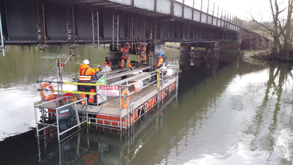 Installing scaffolding on a railway bridge from a 8x4m ScaffFloat pontoon